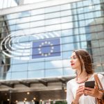 Business woman considers the GDPR in front of parliament building in Brussels